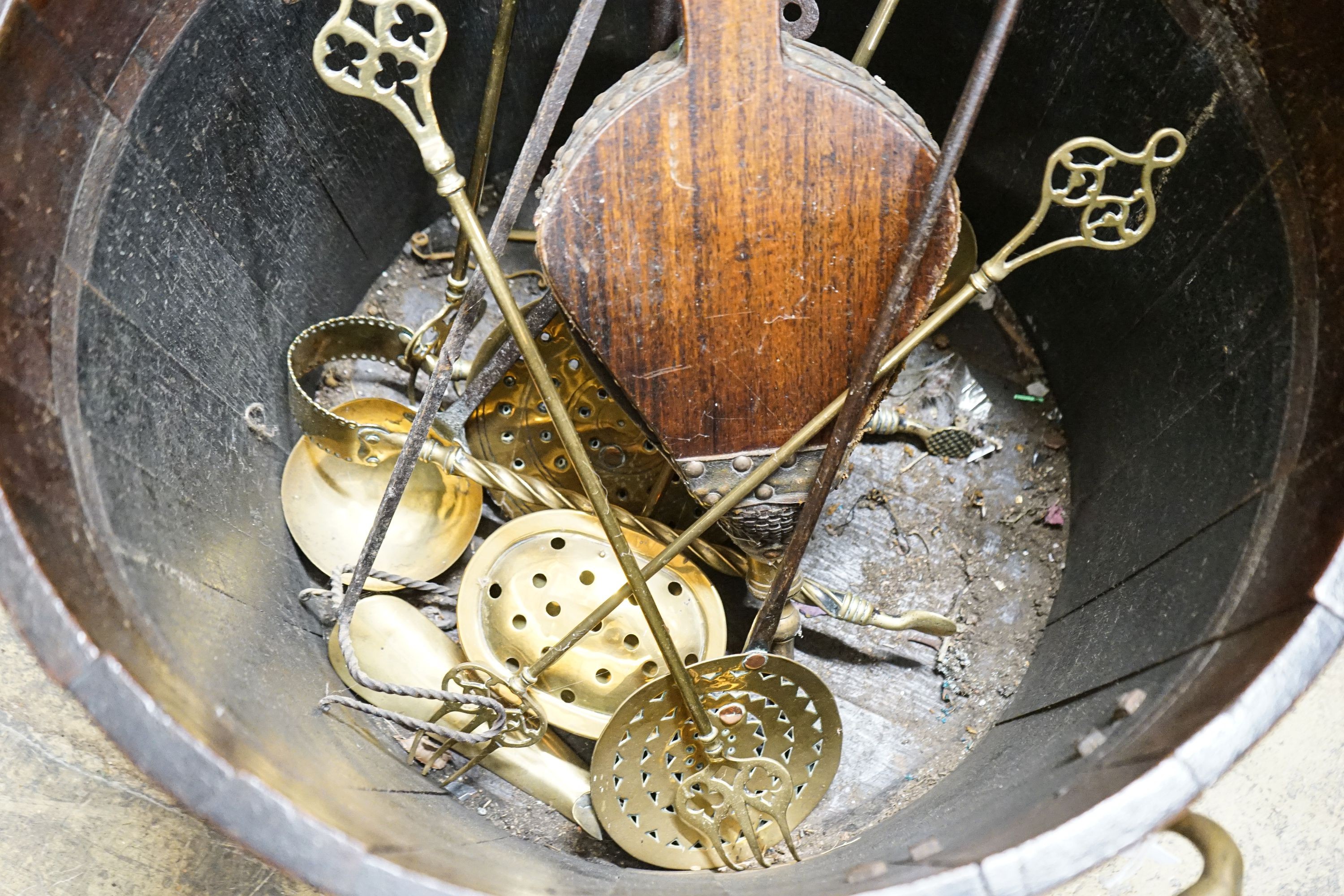 A copper bound staved oak log bin, sundry trivets and fire irons, width over handles 62cm